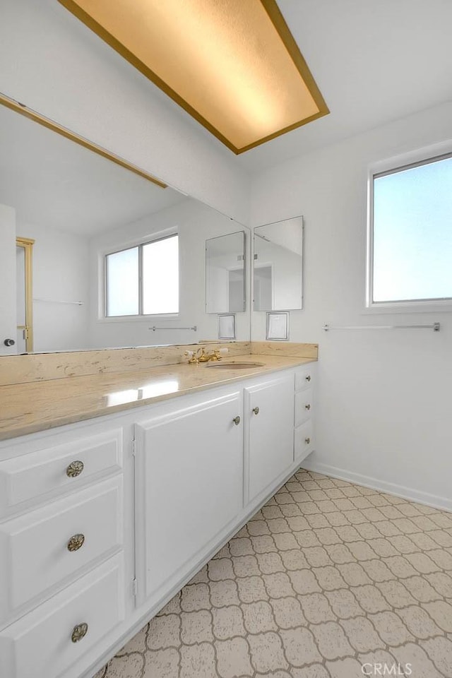 bathroom featuring vanity, a healthy amount of sunlight, and baseboards