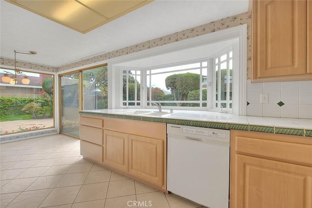 kitchen featuring tile countertops, dishwasher, light brown cabinets, and a sink