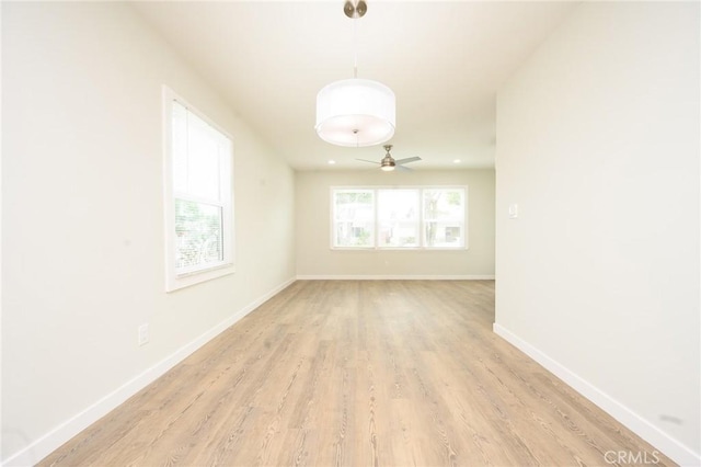 empty room with light wood-style flooring, baseboards, and ceiling fan