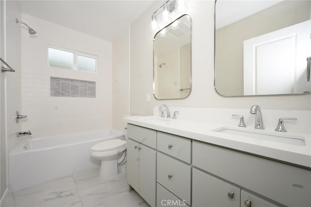 bathroom with marble finish floor, toilet, a sink, and tub / shower combination