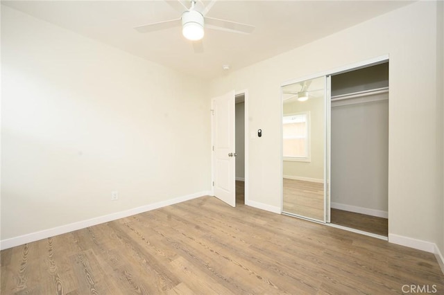 unfurnished bedroom with ceiling fan, baseboards, a closet, and wood finished floors