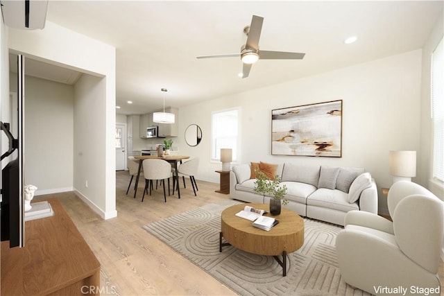 living room with baseboards, ceiling fan, recessed lighting, and light wood-type flooring