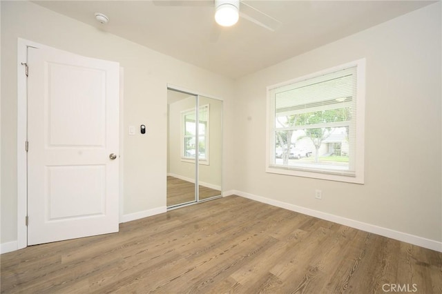 unfurnished bedroom featuring a closet, baseboards, and wood finished floors