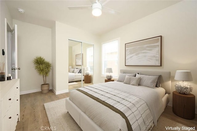 bedroom featuring a ceiling fan, baseboards, and light wood-style floors