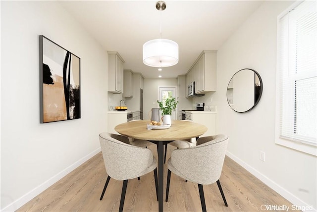 dining room with baseboards and light wood-style flooring