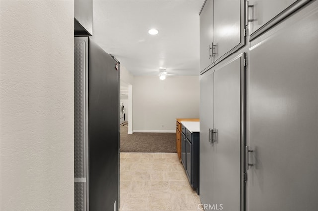 kitchen featuring ceiling fan and light carpet