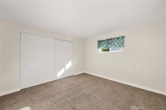 unfurnished bedroom featuring carpet flooring and a closet