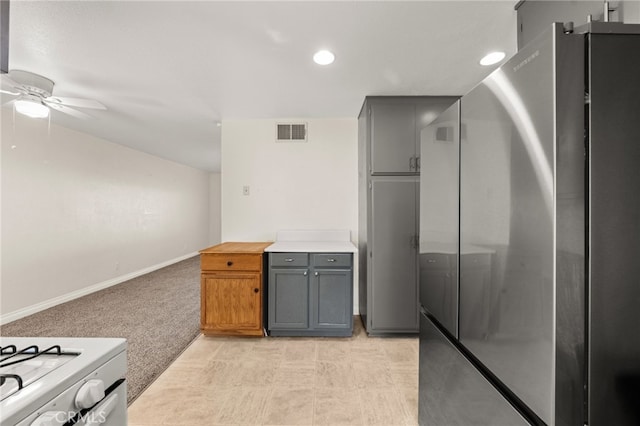 kitchen featuring stainless steel refrigerator, ceiling fan, gray cabinets, and light colored carpet