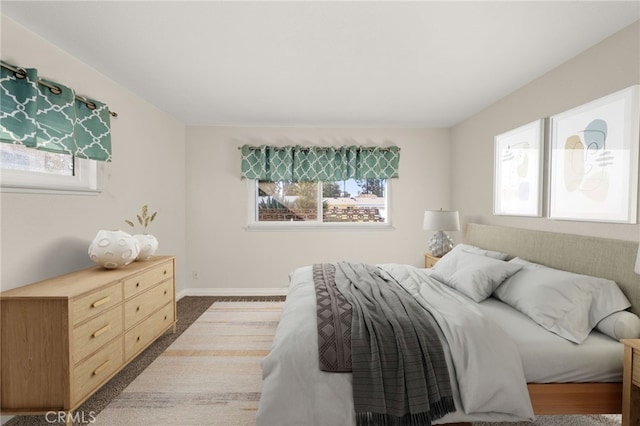 bedroom with dark colored carpet and multiple windows