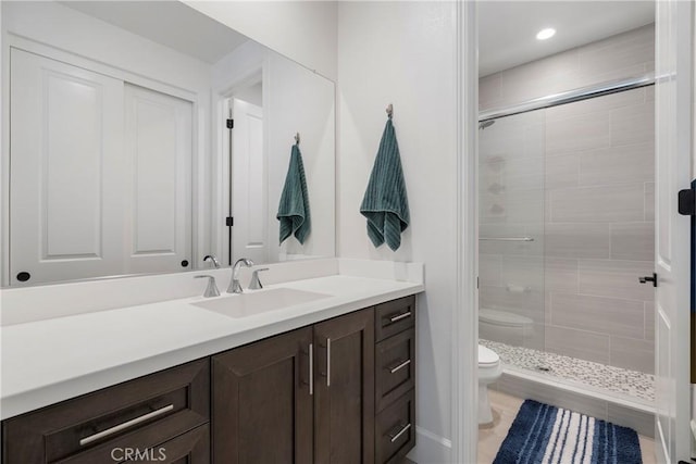 bathroom with toilet, vanity, and an enclosed shower