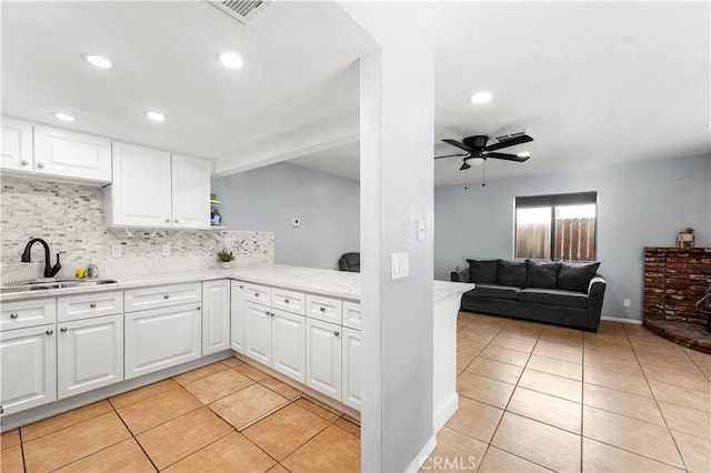 kitchen featuring light tile patterned floors, sink, white cabinetry, and decorative backsplash