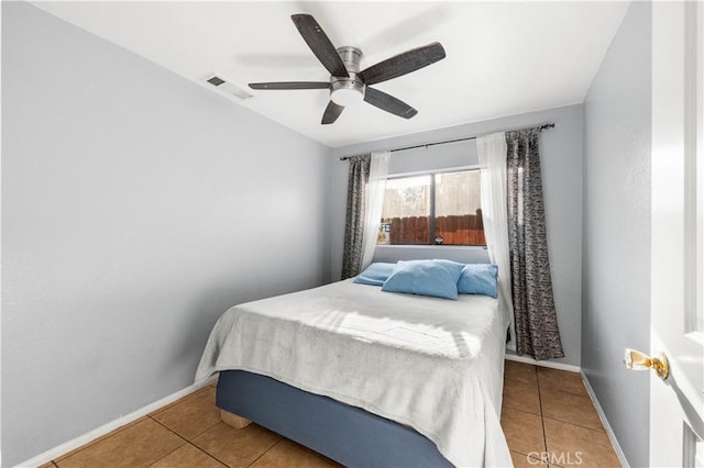 tiled bedroom featuring ceiling fan