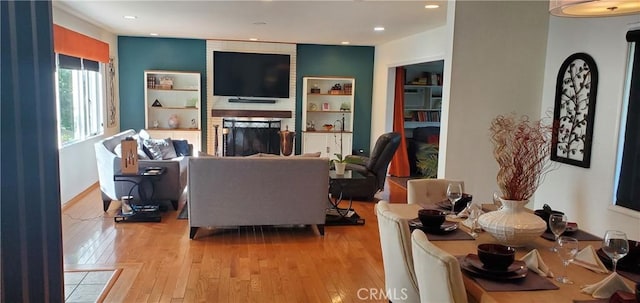 living area featuring light wood-style floors, a fireplace, and recessed lighting