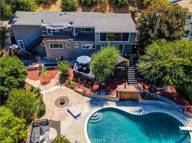 exterior space featuring an outdoor fire pit, an outdoor pool, a patio, and stairs