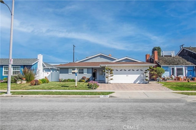 single story home featuring an attached garage, driveway, fence, and a front lawn