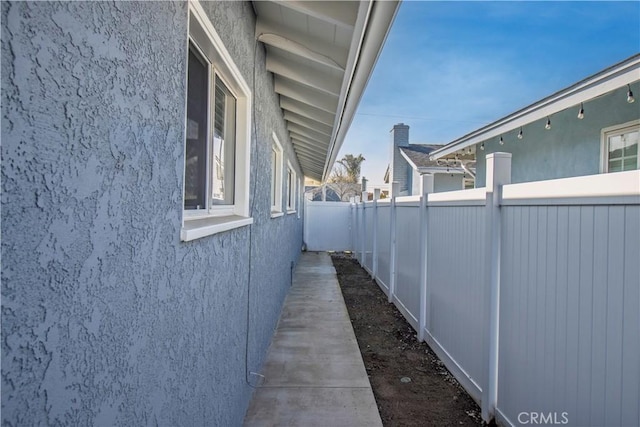 view of side of property featuring fence and stucco siding