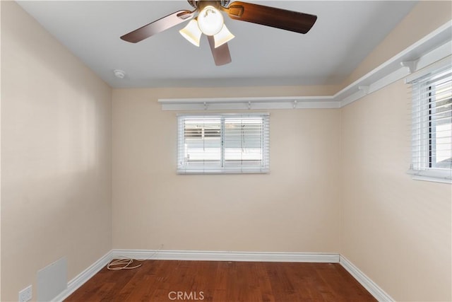 unfurnished room with plenty of natural light, baseboards, and wood finished floors