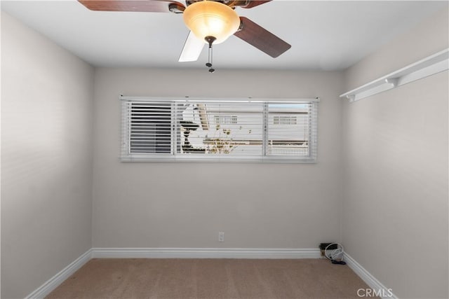 spare room featuring carpet floors, baseboards, and a ceiling fan