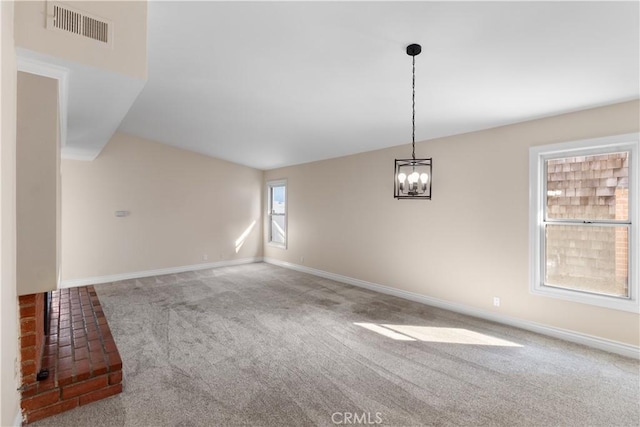 empty room featuring carpet floors, visible vents, a notable chandelier, and baseboards