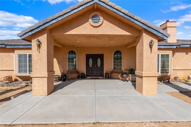 view of exterior entry with a patio