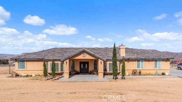 single story home with a mountain view and a patio