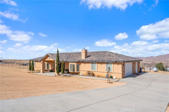 ranch-style house featuring a garage and a mountain view