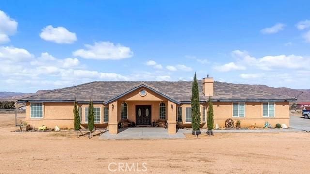 ranch-style home with a mountain view and a patio