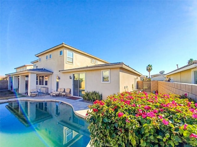 back of house featuring a patio and a fenced in pool