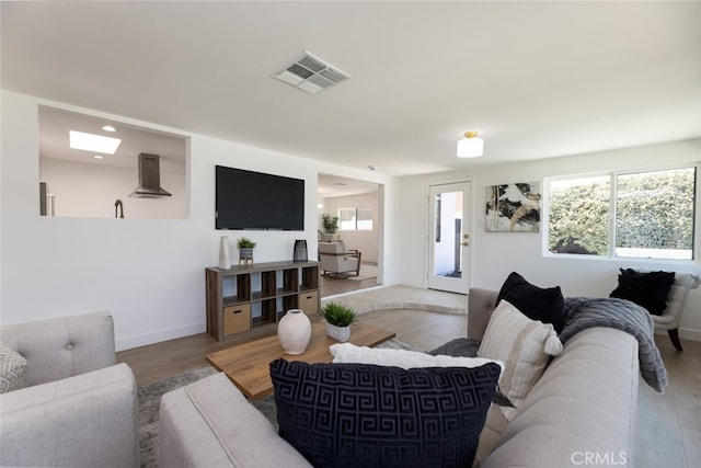 living area featuring recessed lighting, wood finished floors, visible vents, and baseboards