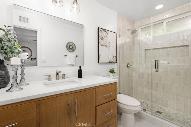 full bathroom with toilet, a shower stall, visible vents, and vanity