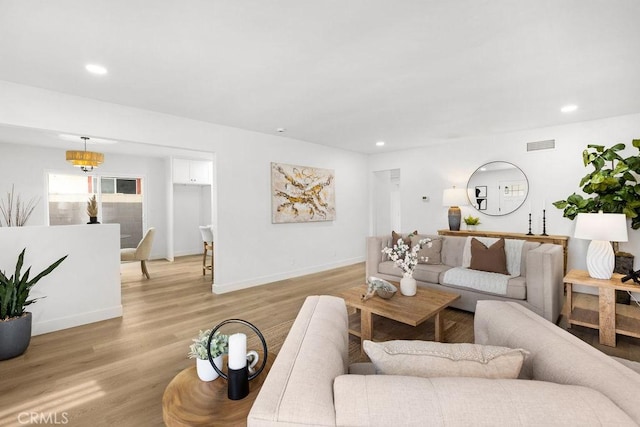 living room featuring visible vents, light wood-style flooring, and recessed lighting