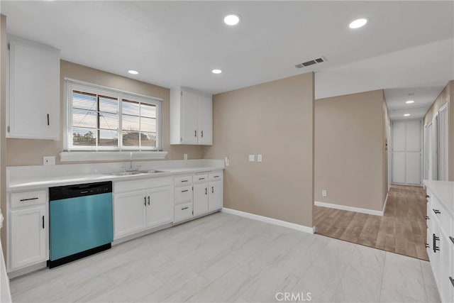 kitchen featuring light countertops, white cabinets, a sink, and stainless steel dishwasher