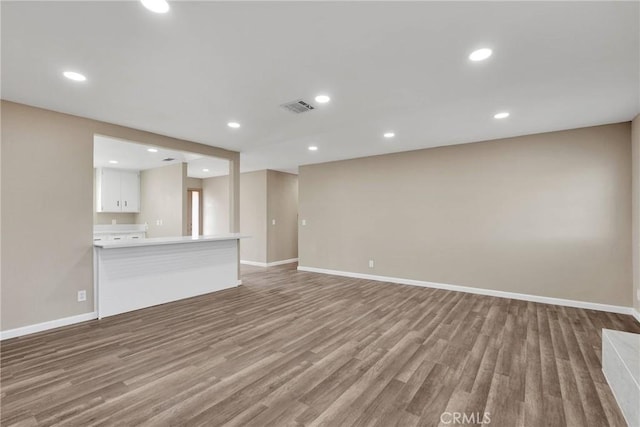 unfurnished living room with visible vents, wood finished floors, and recessed lighting