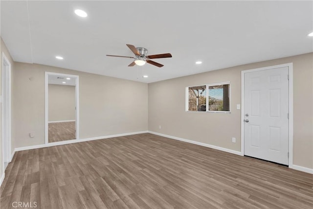 spare room featuring light wood-type flooring, baseboards, a ceiling fan, and recessed lighting