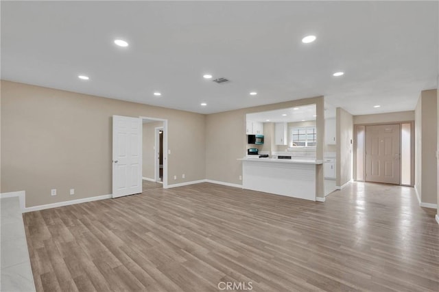 unfurnished living room with recessed lighting, visible vents, and light wood-style flooring