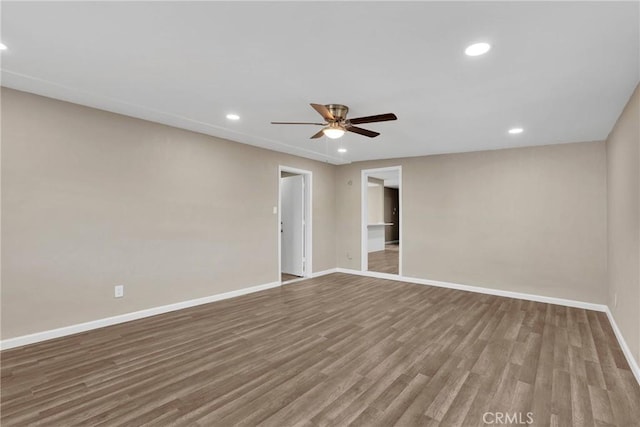 spare room featuring recessed lighting, wood finished floors, and baseboards