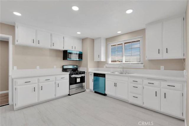 kitchen with stainless steel appliances, white cabinets, light countertops, and a sink