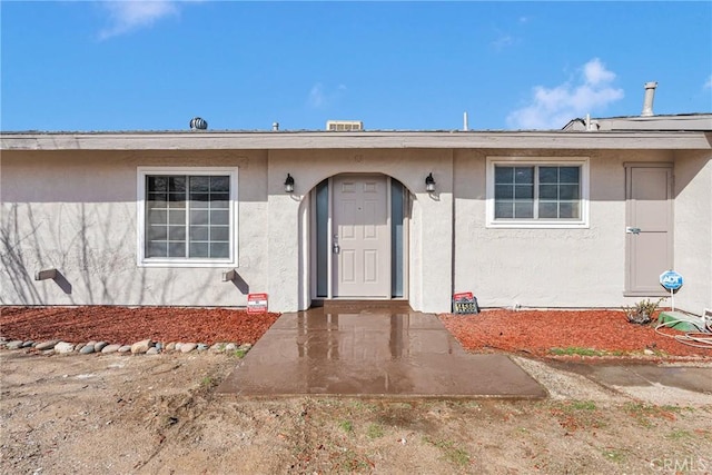 view of exterior entry featuring stucco siding