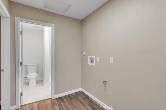 laundry area with laundry area, attic access, baseboards, wood finished floors, and washer hookup