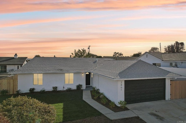 ranch-style house featuring a garage and a yard