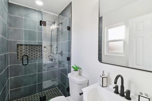 bathroom featuring sink, toilet, and a shower with shower door