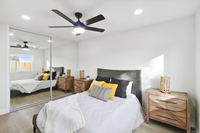 bedroom with ceiling fan, light wood-type flooring, and a closet