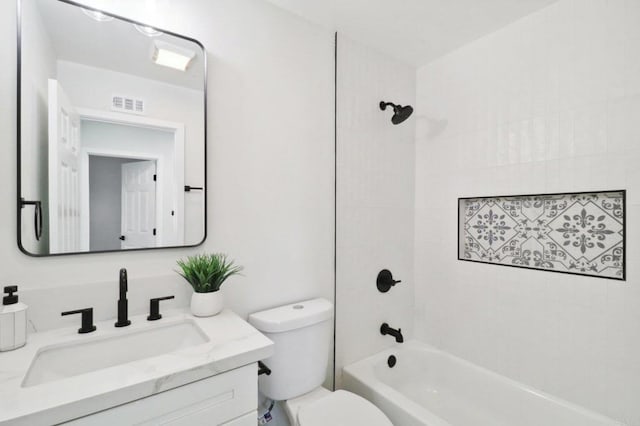 full bathroom featuring tiled shower / bath combo, toilet, and vanity