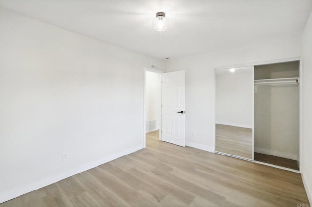 unfurnished bedroom featuring a closet and light hardwood / wood-style flooring