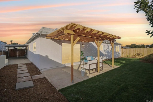 patio terrace at dusk with a pergola and a lawn