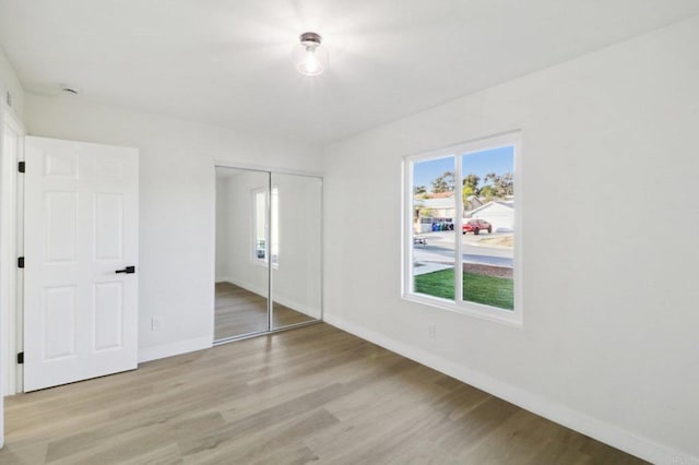 unfurnished bedroom with a closet and light hardwood / wood-style flooring