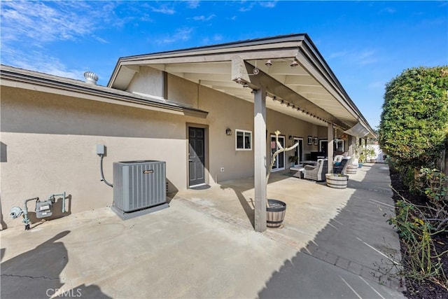 back of property with central AC, a patio area, and outdoor lounge area