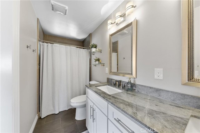 bathroom featuring toilet, tile patterned flooring, and vanity