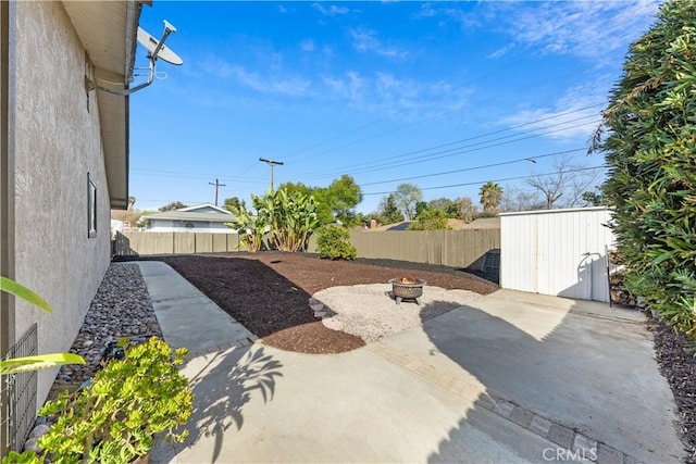 view of patio / terrace with a storage unit and a fire pit