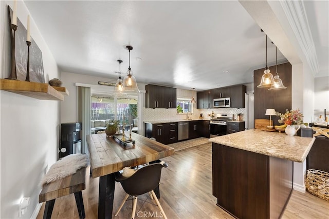 kitchen featuring appliances with stainless steel finishes, light hardwood / wood-style floors, kitchen peninsula, dark brown cabinets, and tasteful backsplash